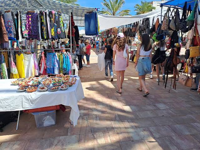 Flags and busy market stalls near Plaza Major