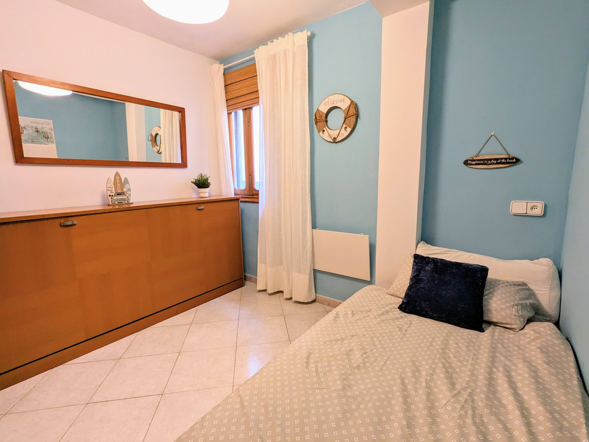 Inner Year Room with single bed, mirror and beach-themed decor